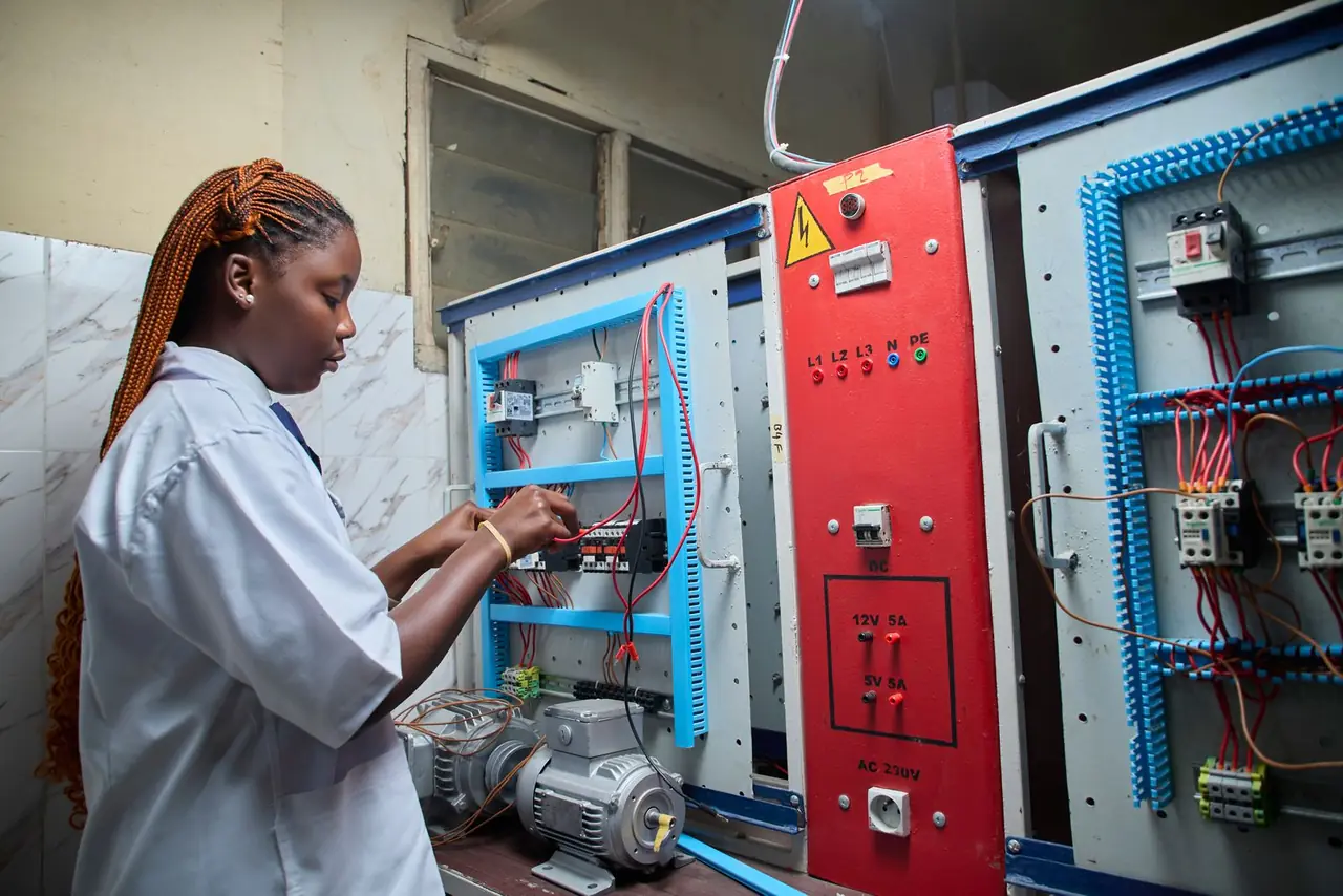 A technician working inside an electrical control panel