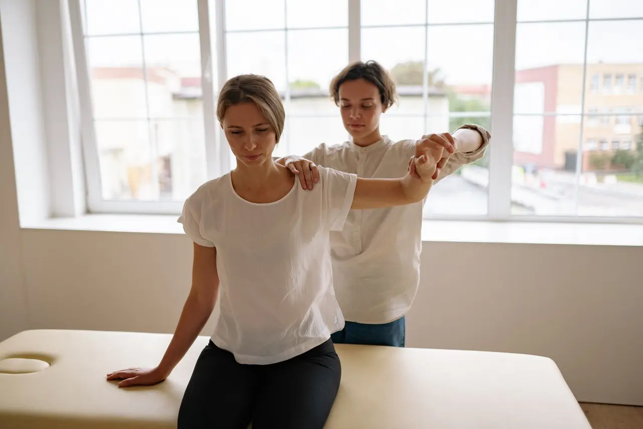 A therapist guiding a patient through an arm stretch