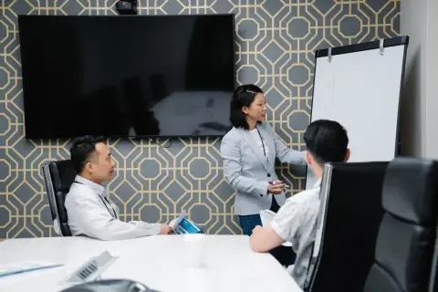A professional conducting a presentation in a modern office space with colleagues engaged.