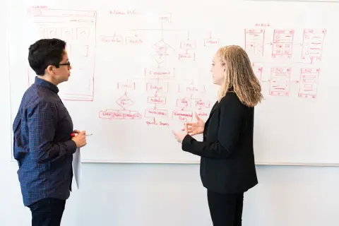 Two people working through a campaign structure on a whiteboard